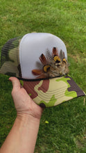 Load and play video in Gallery viewer, Feather Trucker Hat with Brass Rivet, Woman's Western Cowgirl Camo Foam Snapback w/ Rope detail, Boho Rodeo Cap, Pheasant Feather design on Camouflage cap
